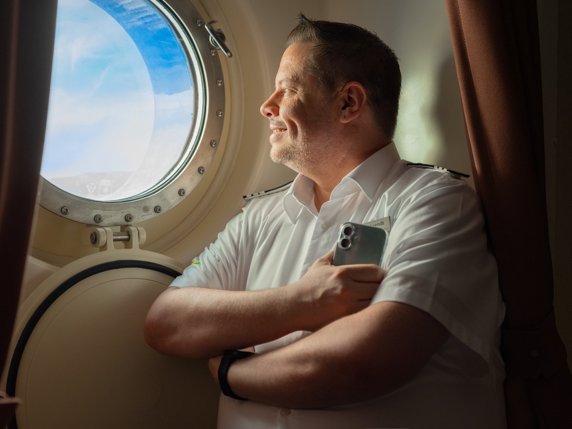 AIDA crew member on cabin and looking out of the window 