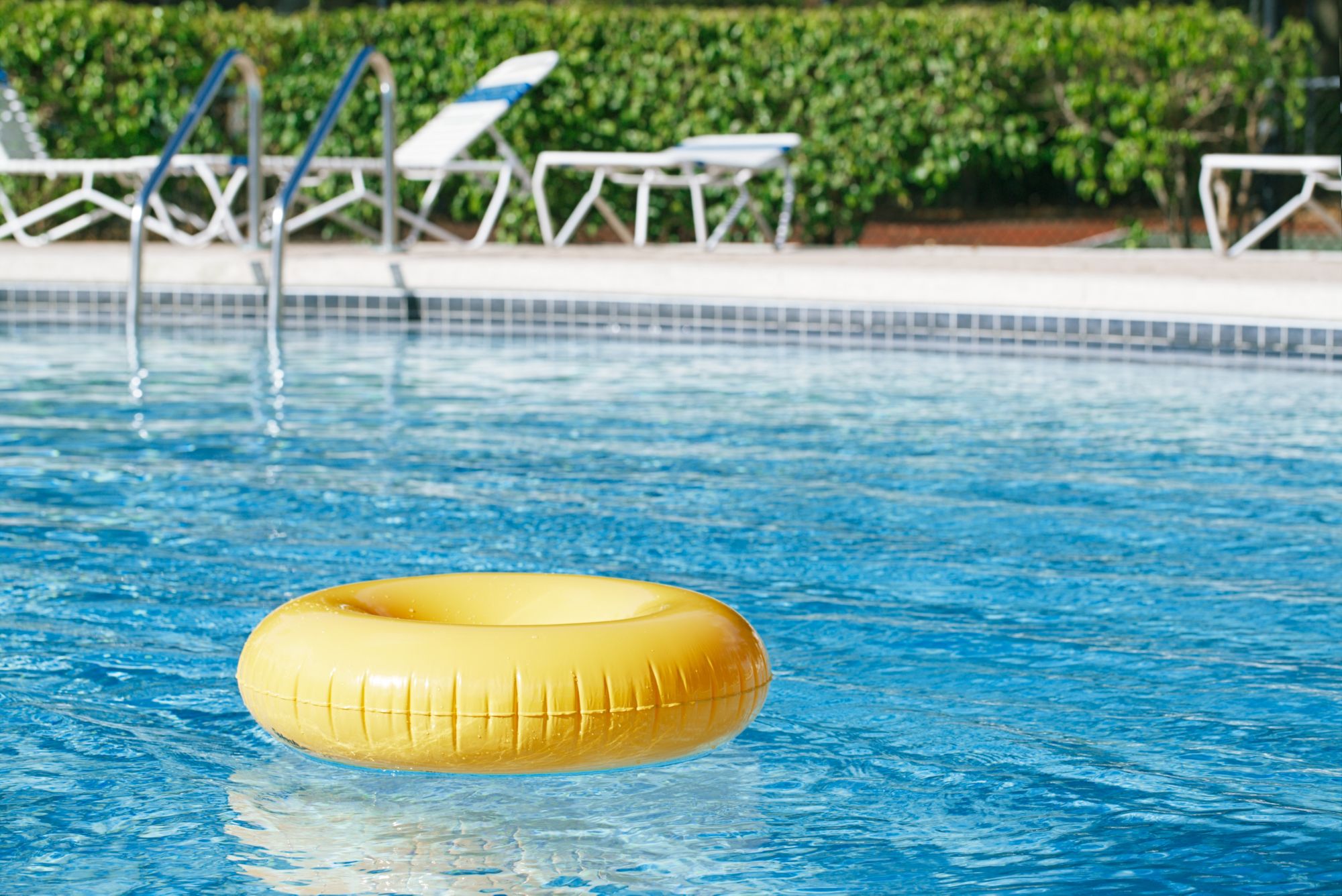 floating ring on blue water swimpool with waves reflecting in the summer sun