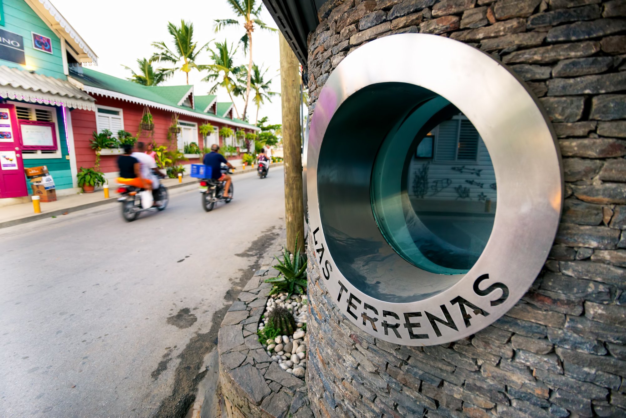 Las Terranes, Dominican Republic - September 17, 2014: Las Terrenas written under window and main street with motorbikes in motiocentertypical colorful houses as background.