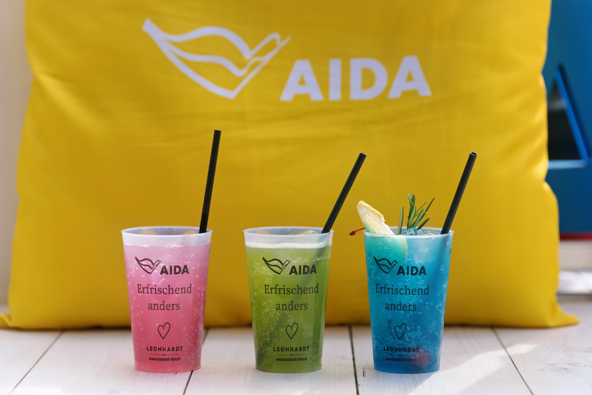 Drei farbenfrohe Getränke in AIDA Getränkebechern