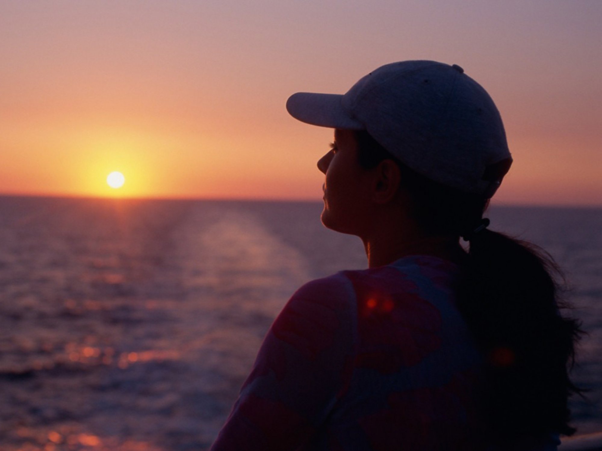 Frau schaut den Sonnenuntergang an