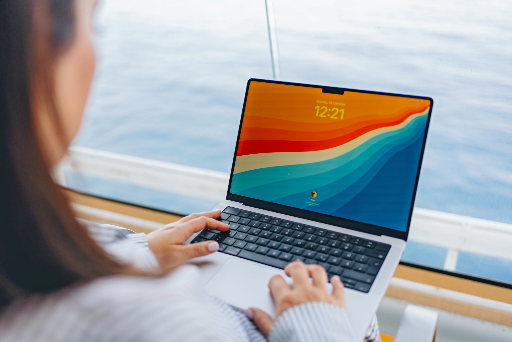 Eine Frau sitzt an Bord mit einem aufgeklappten Laptop