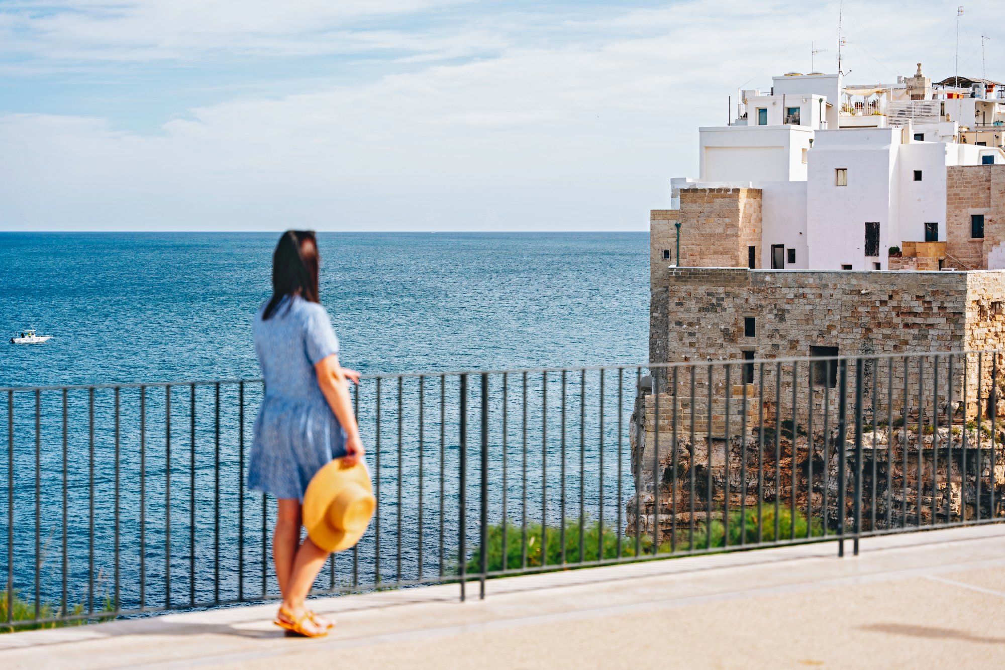 Frau an einer Balustrade mit Blick aufs Meer