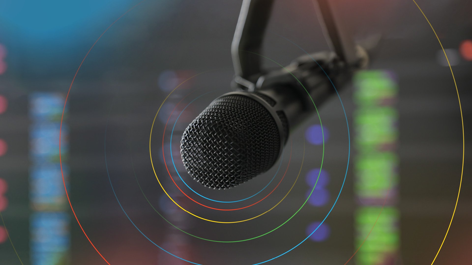 Ein schwarzes Mikrophone, das von schrägrechts oben in das Bild ragt.