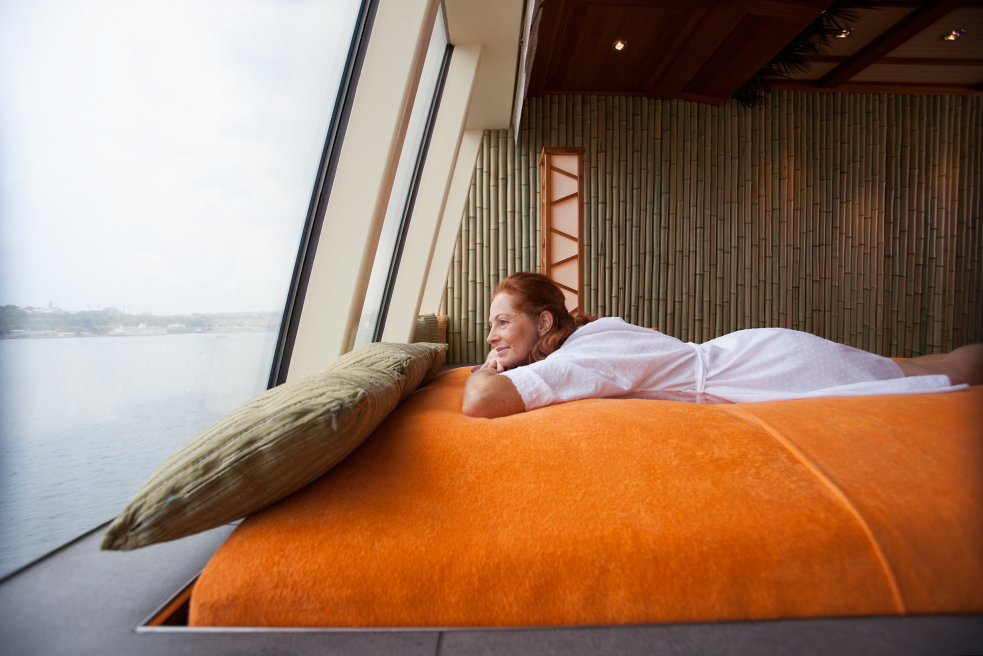 Eine Frau genießt in der Wellness-Suite den Blick auf das Meer