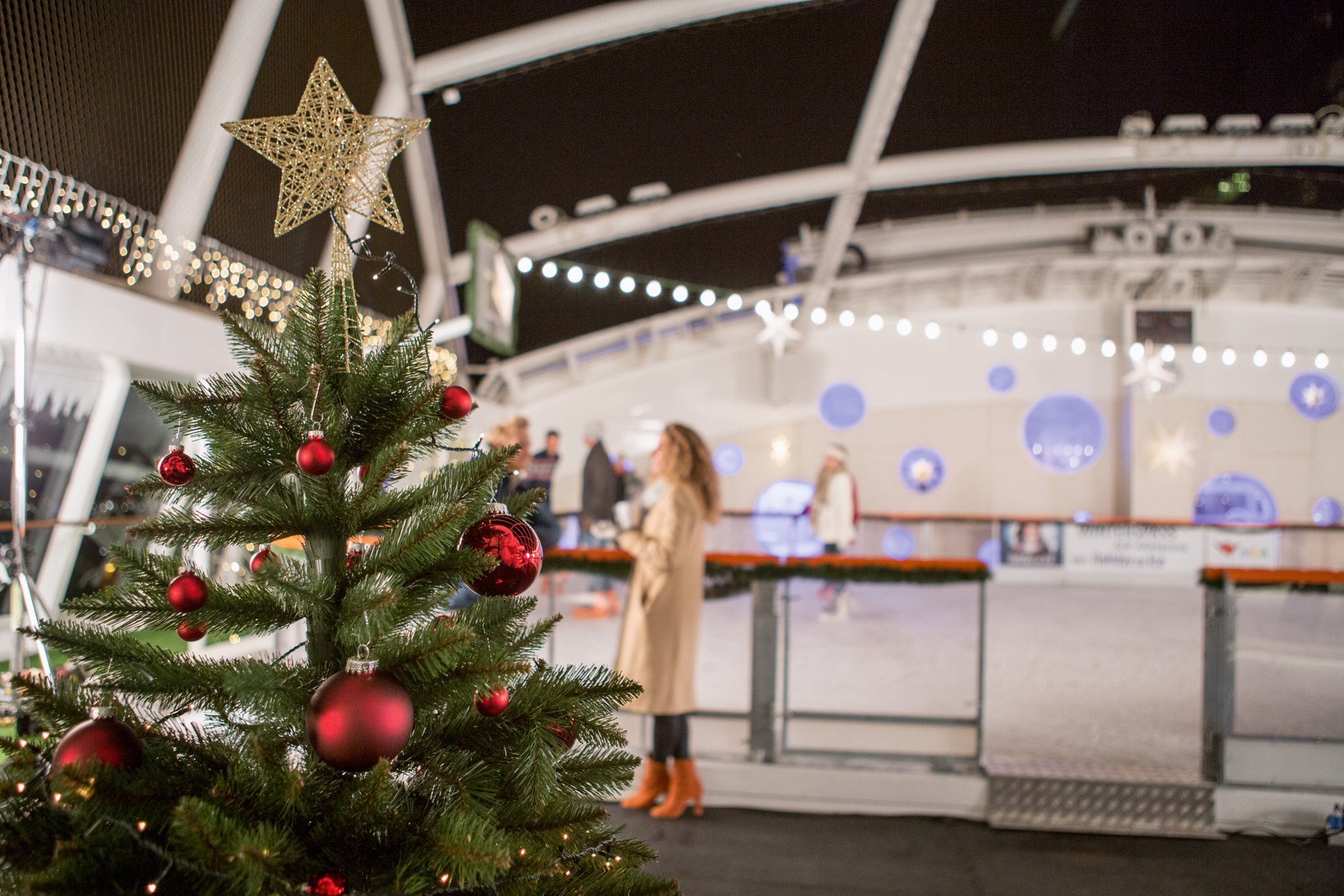 Weihnachtsbaum im Vordergrund, dahinter eine Eisbahn an Bord von AIDA