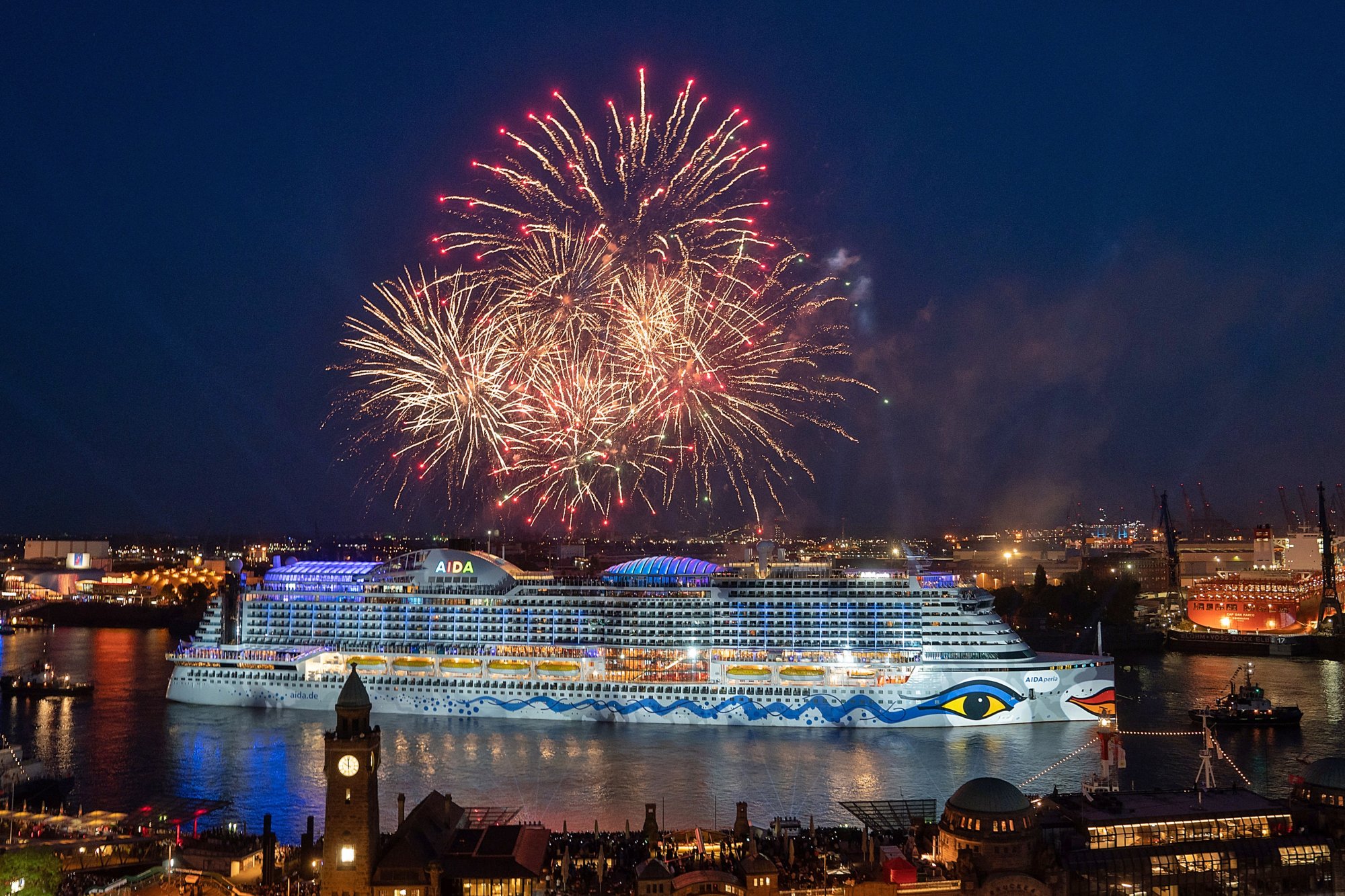 AIDAnova mit Feuerwerk im Hafen im Hintergrund