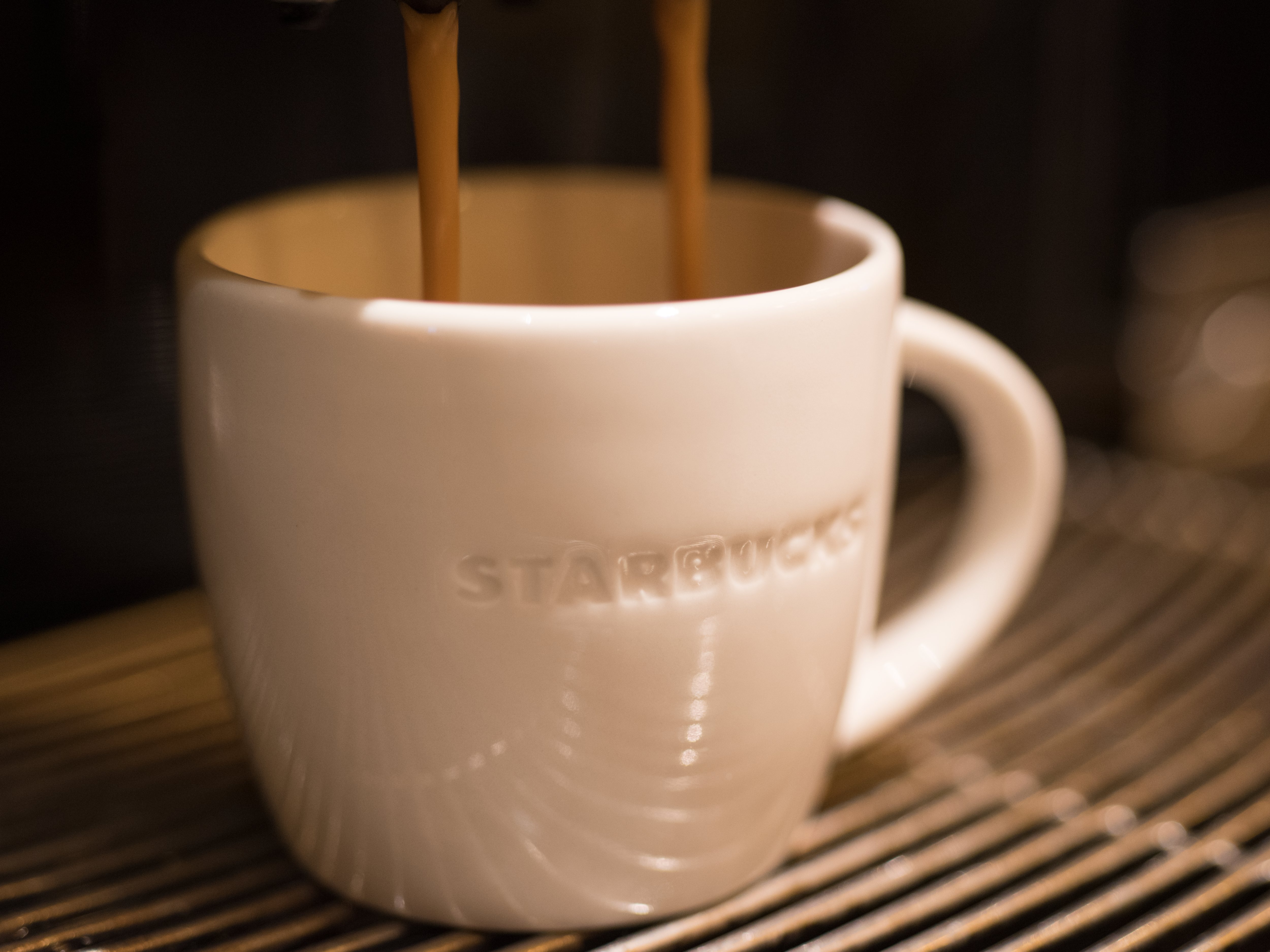 Starbucks Tasse wird mit Kaffee gefüllt