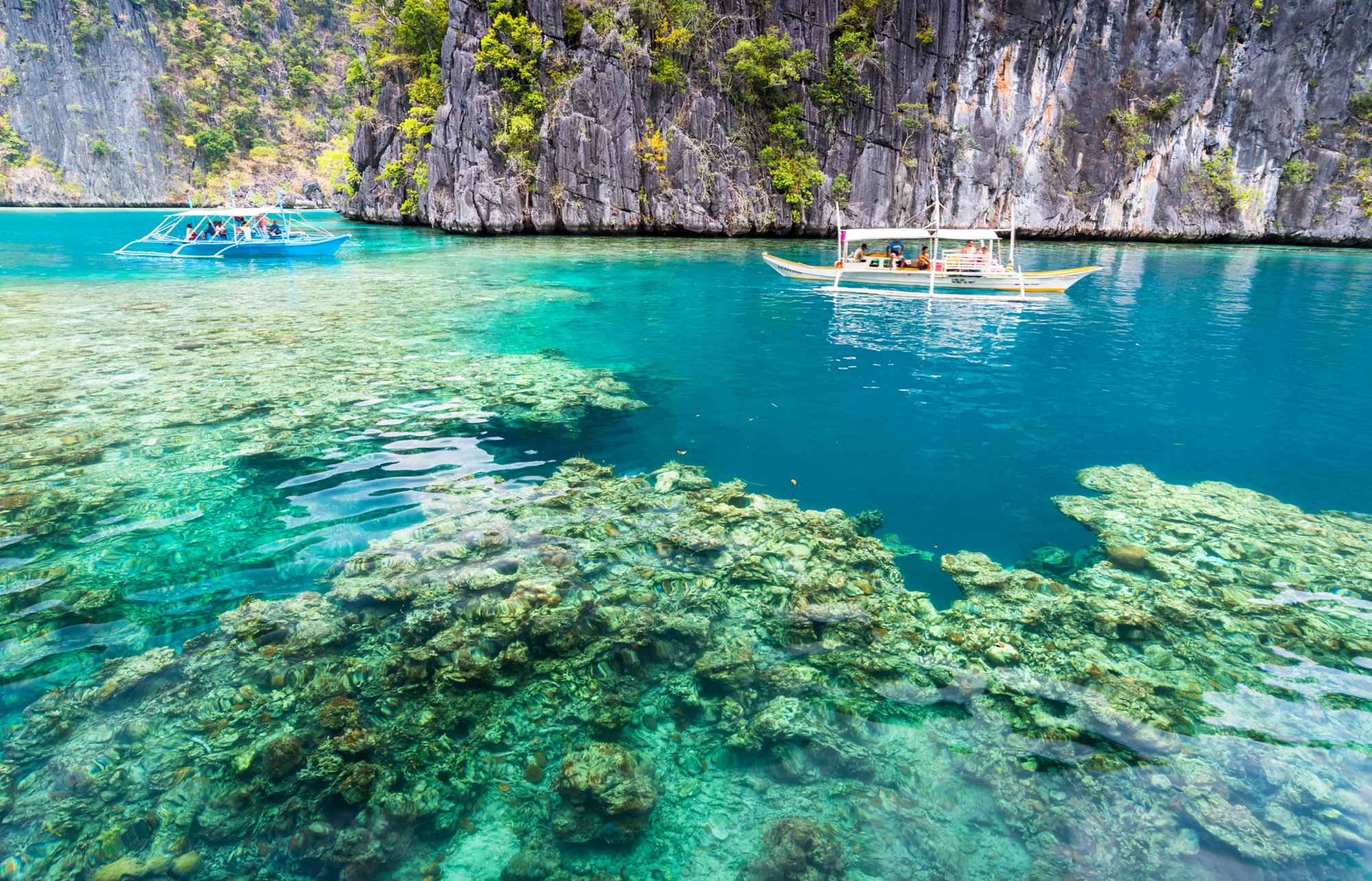 View of Kayangan Lake lagoon with tourists boat and coral reef on Coron island, Busuanga Palawan Philippines