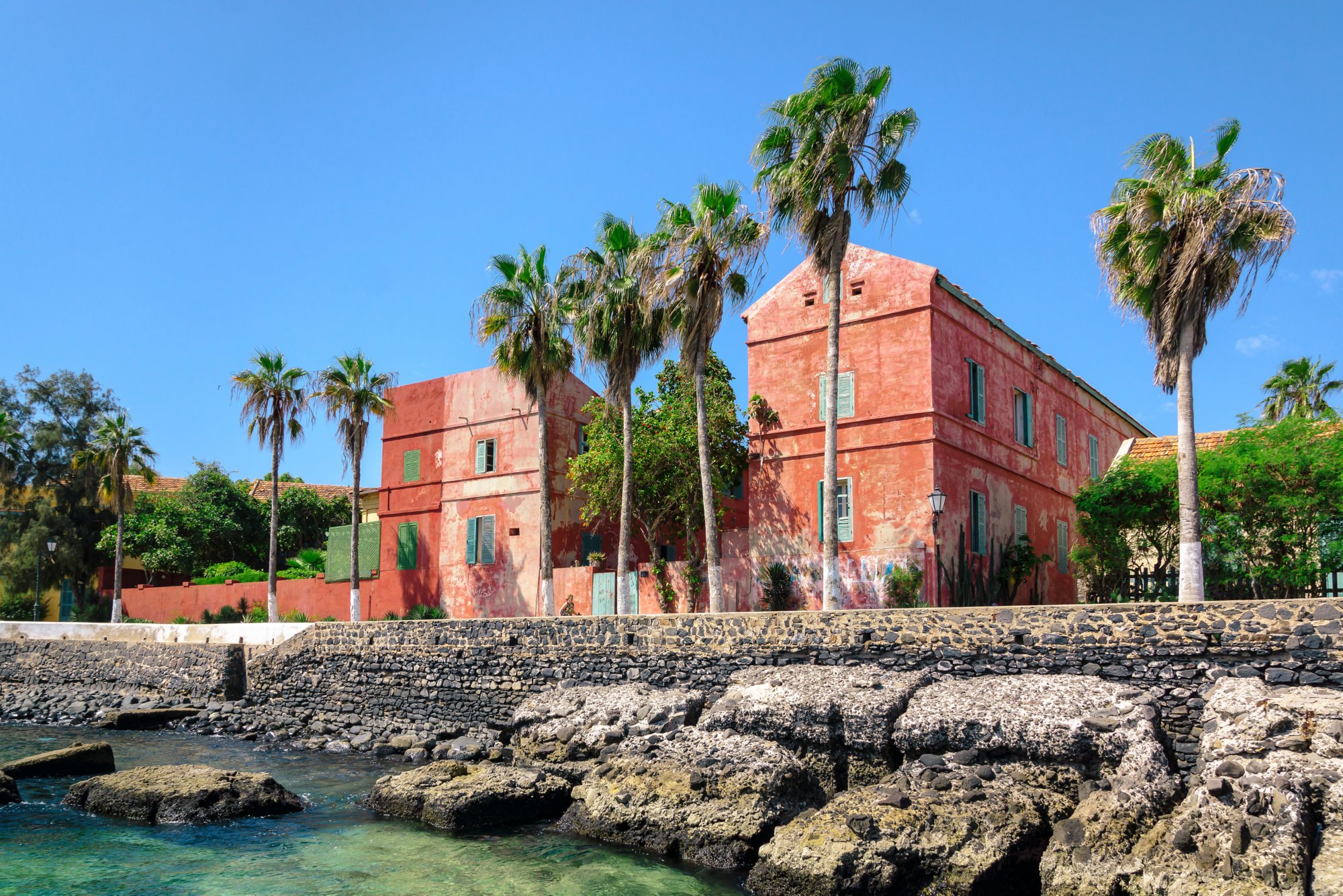 Old red houses in the street along the coast of Goree Island, Senegal