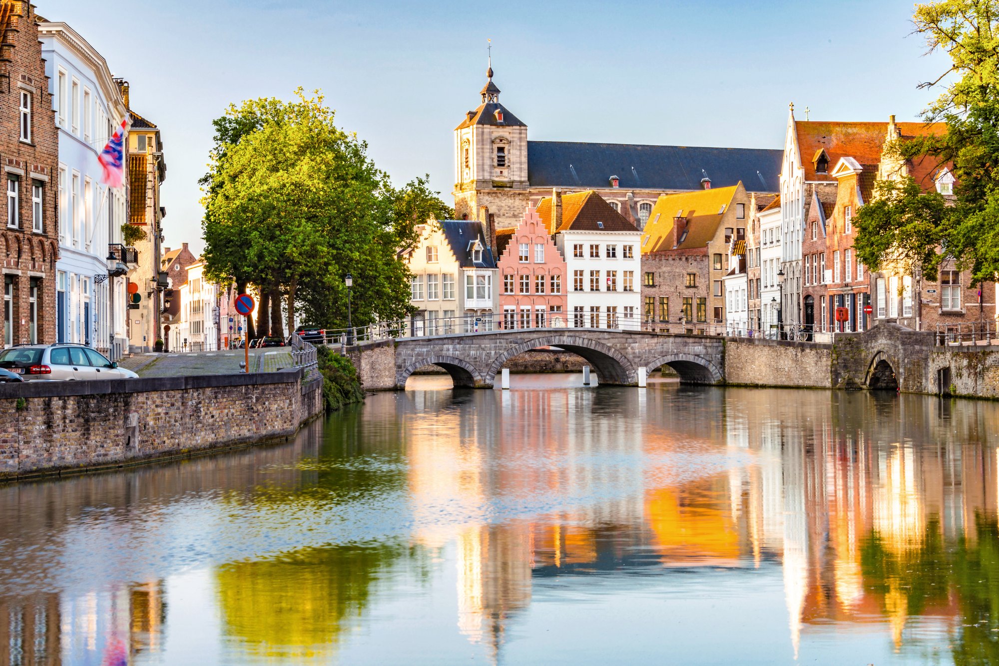 CTXWT3 Just after sunrise view of canal in Brugge with bridge and buildings reflected in the still water