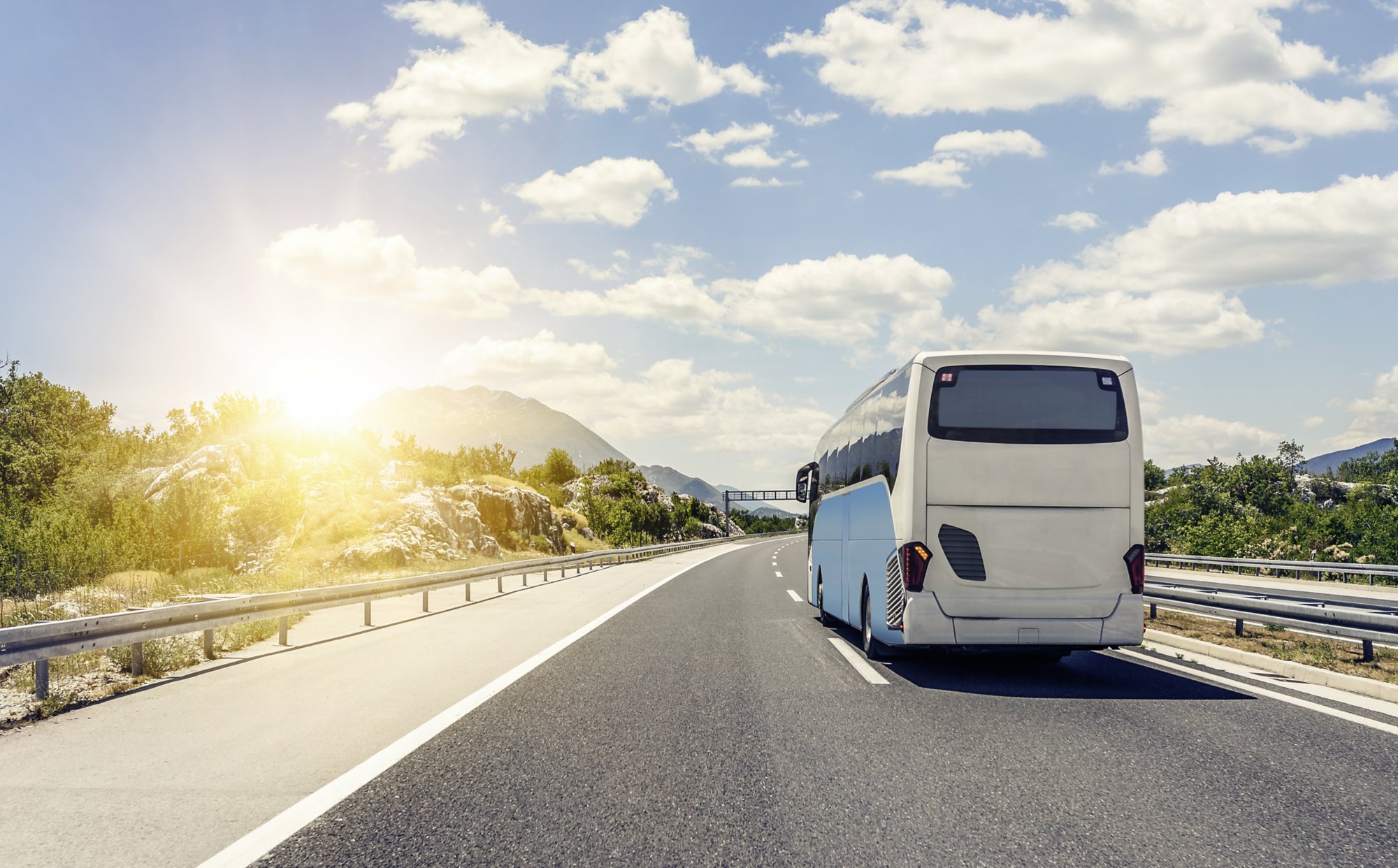 Tourist bus rushes along the asphalt high-speed highway.