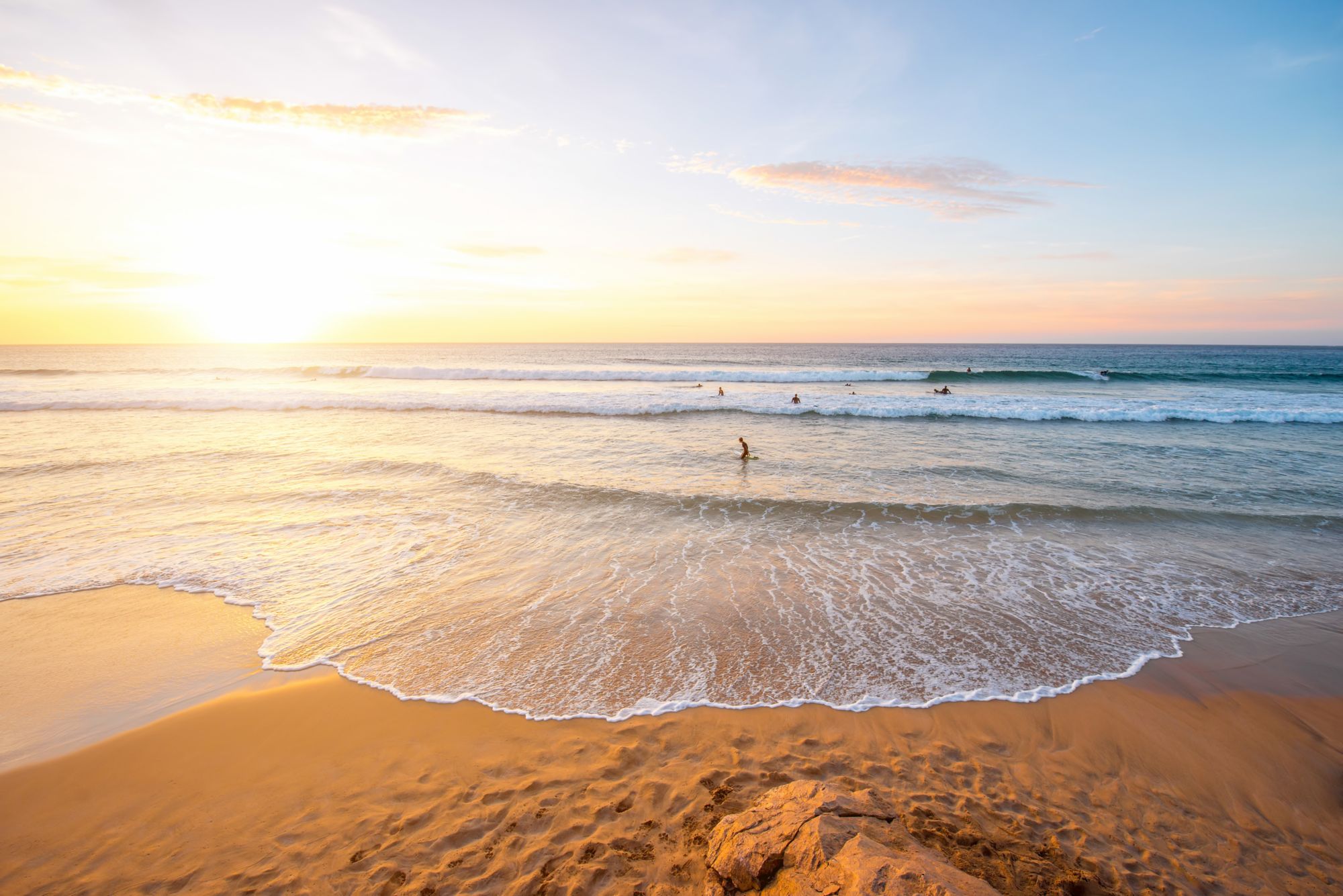 Beautiful beach with surfers swimming near El Cotillo village on Fuerteventura island in Spain
