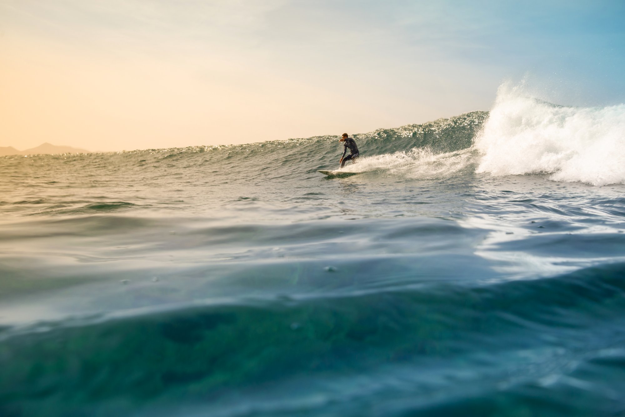 Surfer riding waves on the island of fuerteventura in the Atlantic Ocean, Canary Islands