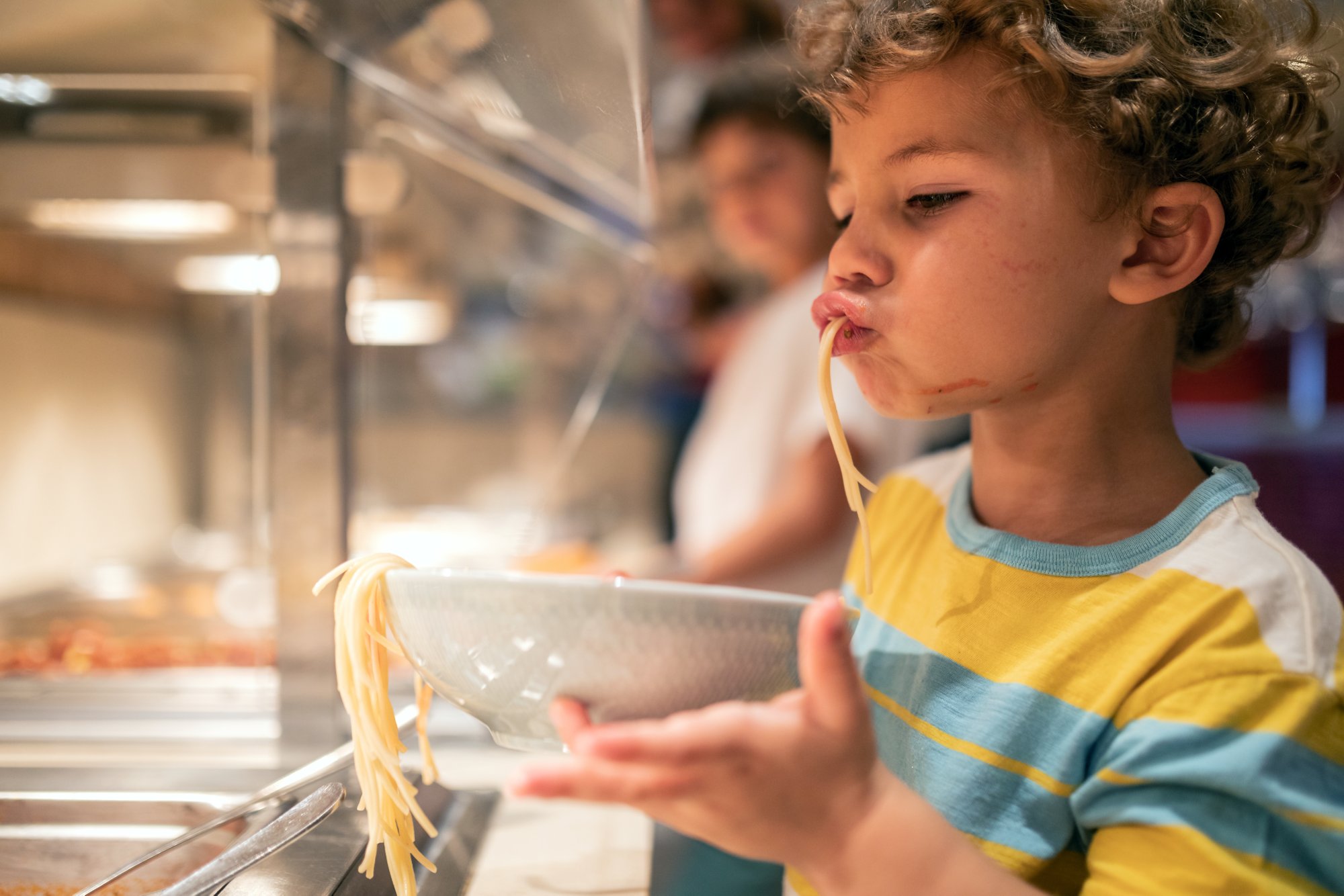 Kind mit Spaghetti Teller