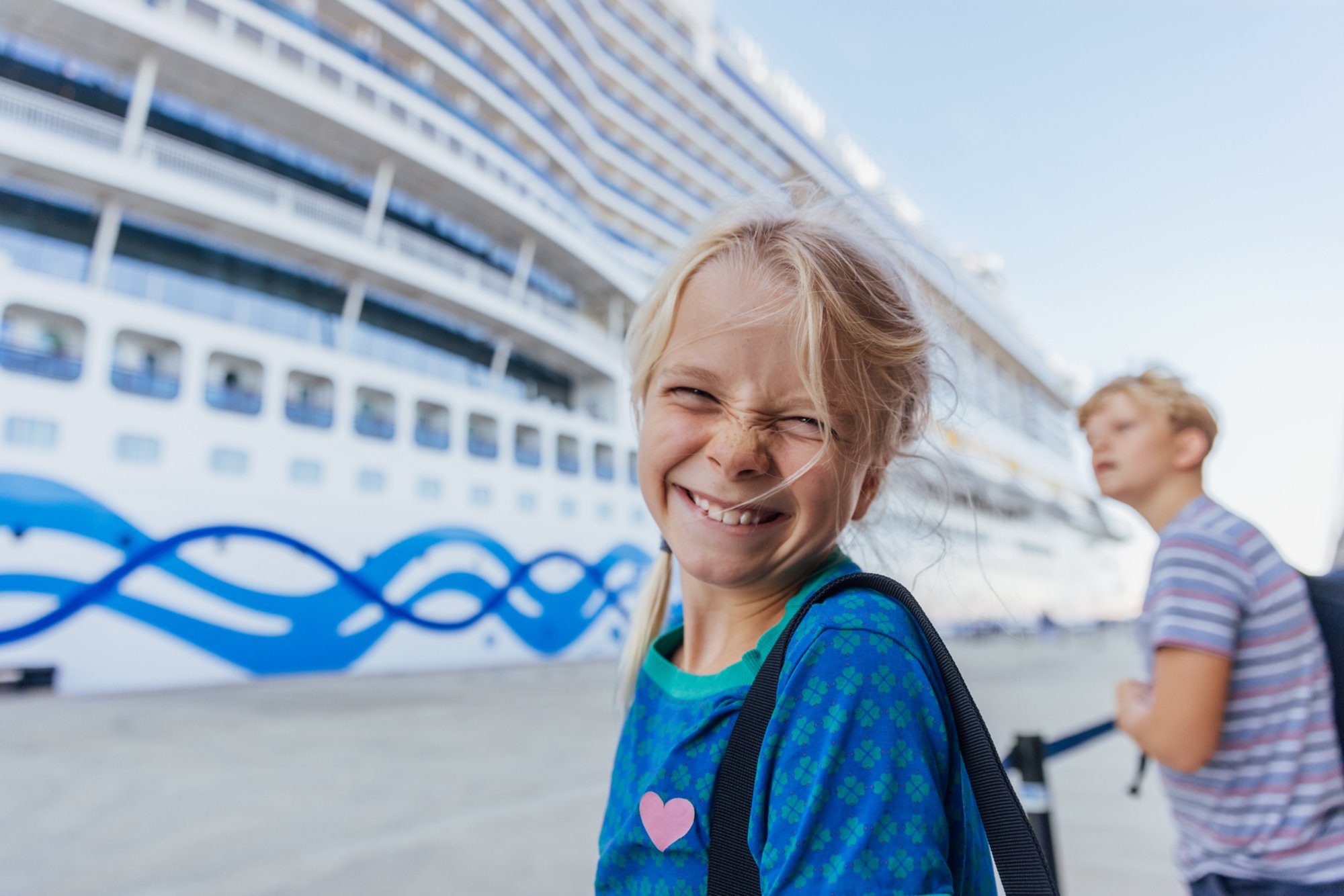 Zwei Kinder am Hafen vor einem AIDA Schiff