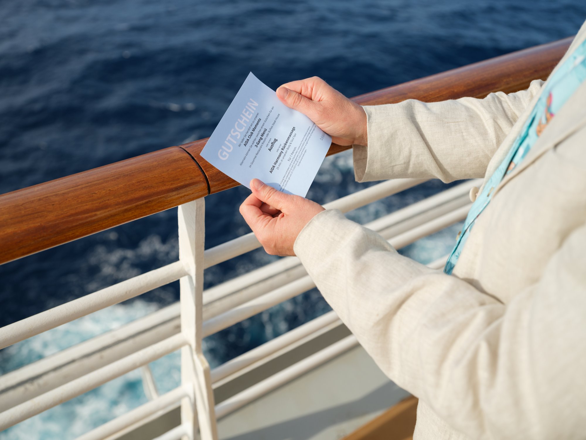 Person hält AIDA Gutschein in Händen