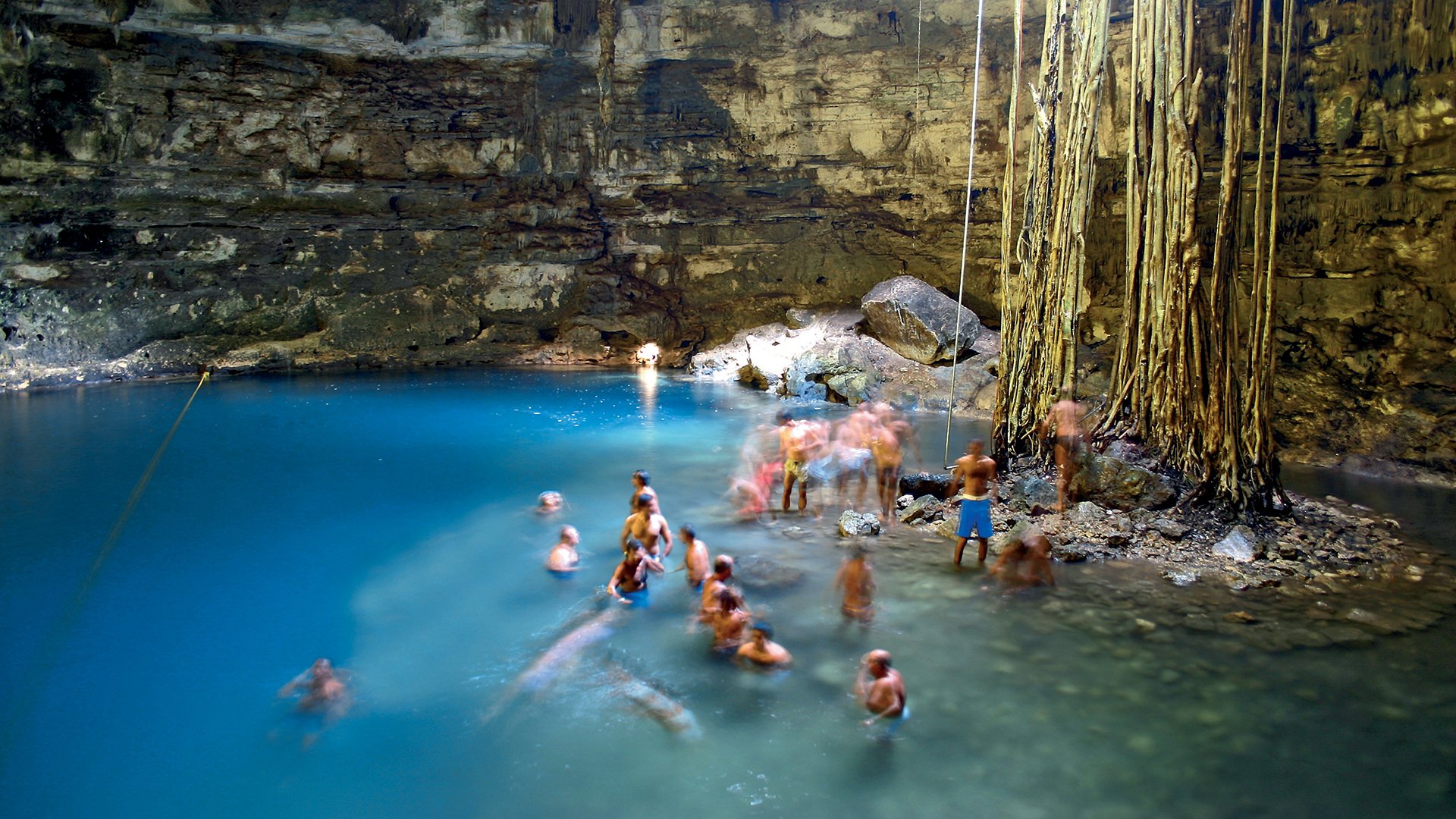 People bathing in limestone cave lake in Yucatan, Mexico

cave, cavern, pool, lake, lagoon, underground, grotto, spa, health, tourism, water, green, blue, crowd, tree, roots, cenote, mexico, yucatan, 
