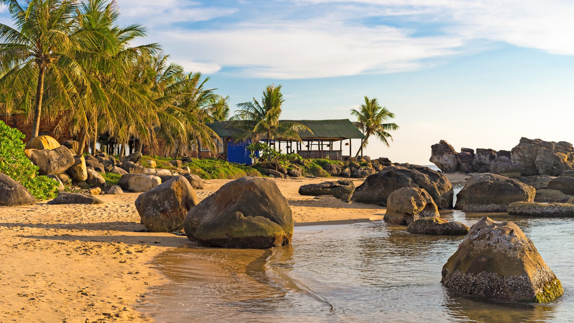 Seashore with stones in water on coastline at sunset on Long Beach of Phu Quoc island in Vietnam