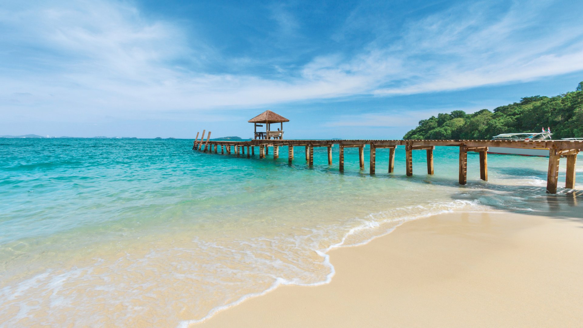 Wooden bridge pier leading to summer tropical sea with blue sky at Koh Samed Island, famous tourist attraction in Rayong province, Thailand.