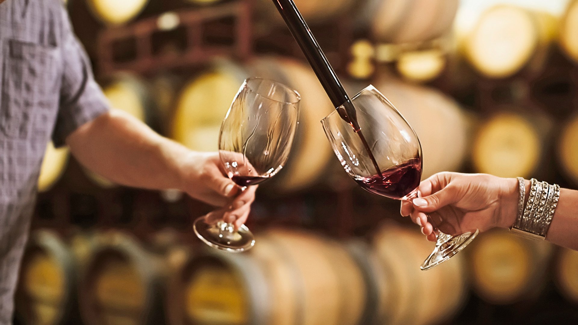Caucasian couple tasting wine in cellar