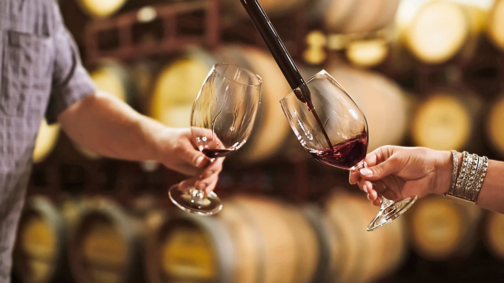 Caucasian couple tasting wine in cellar