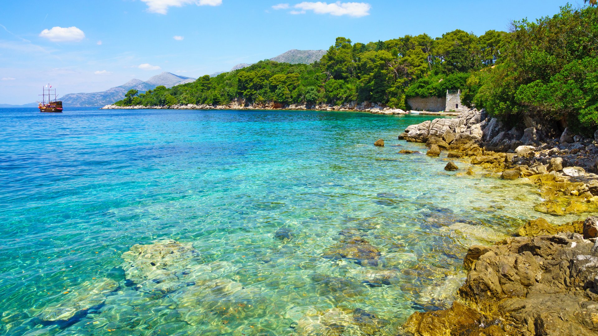 A rocky shore, boats and a ship, in the Kolocep Island, one of the Elaphiti Islands, Croatia