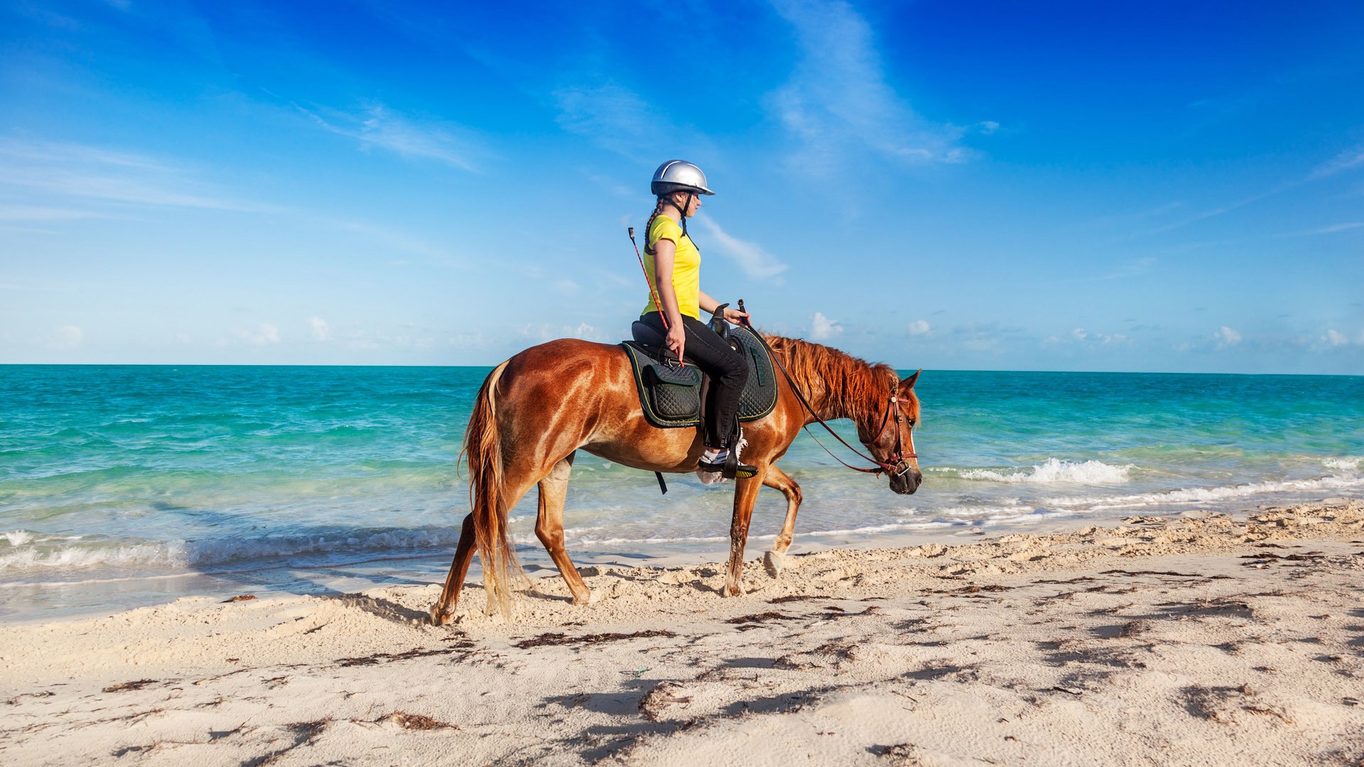 Teenage girl finishing a ride on Long Bay Beach, Providenciales, Turks and Caicos