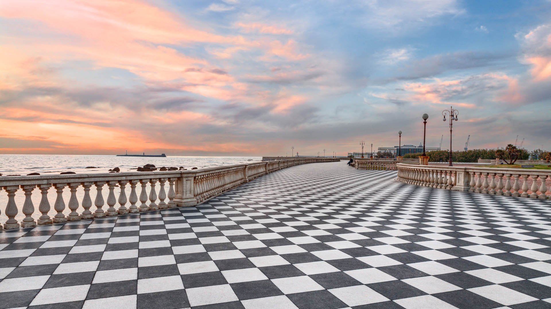 Mascagni Terrace, promenade of Livorno, Tuscany, Italy, picturesque seashore at sunset with black and white checkered pavement and columned bannister