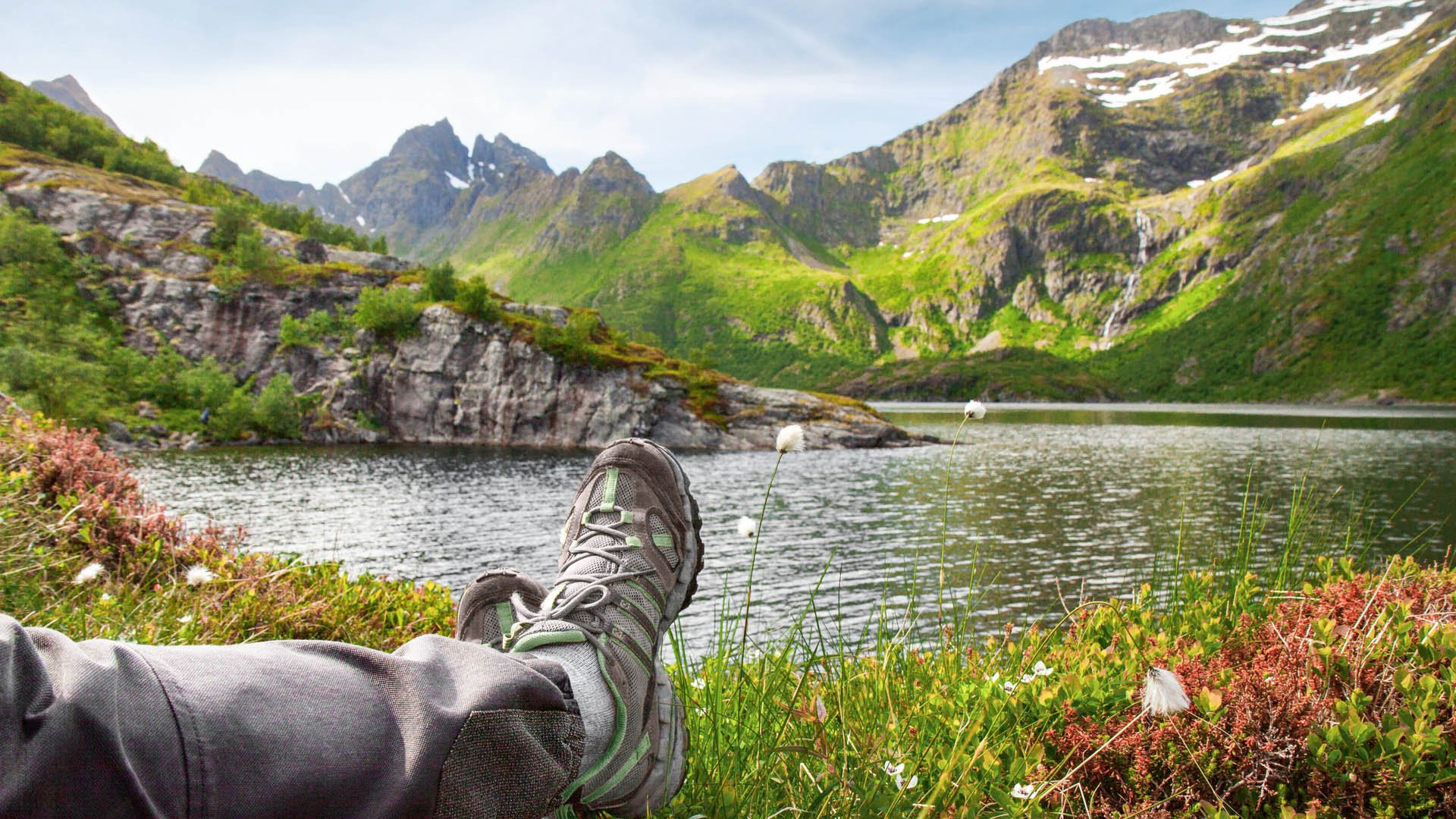 Hiker relaxing near mountain lake, Lofoten, Norway