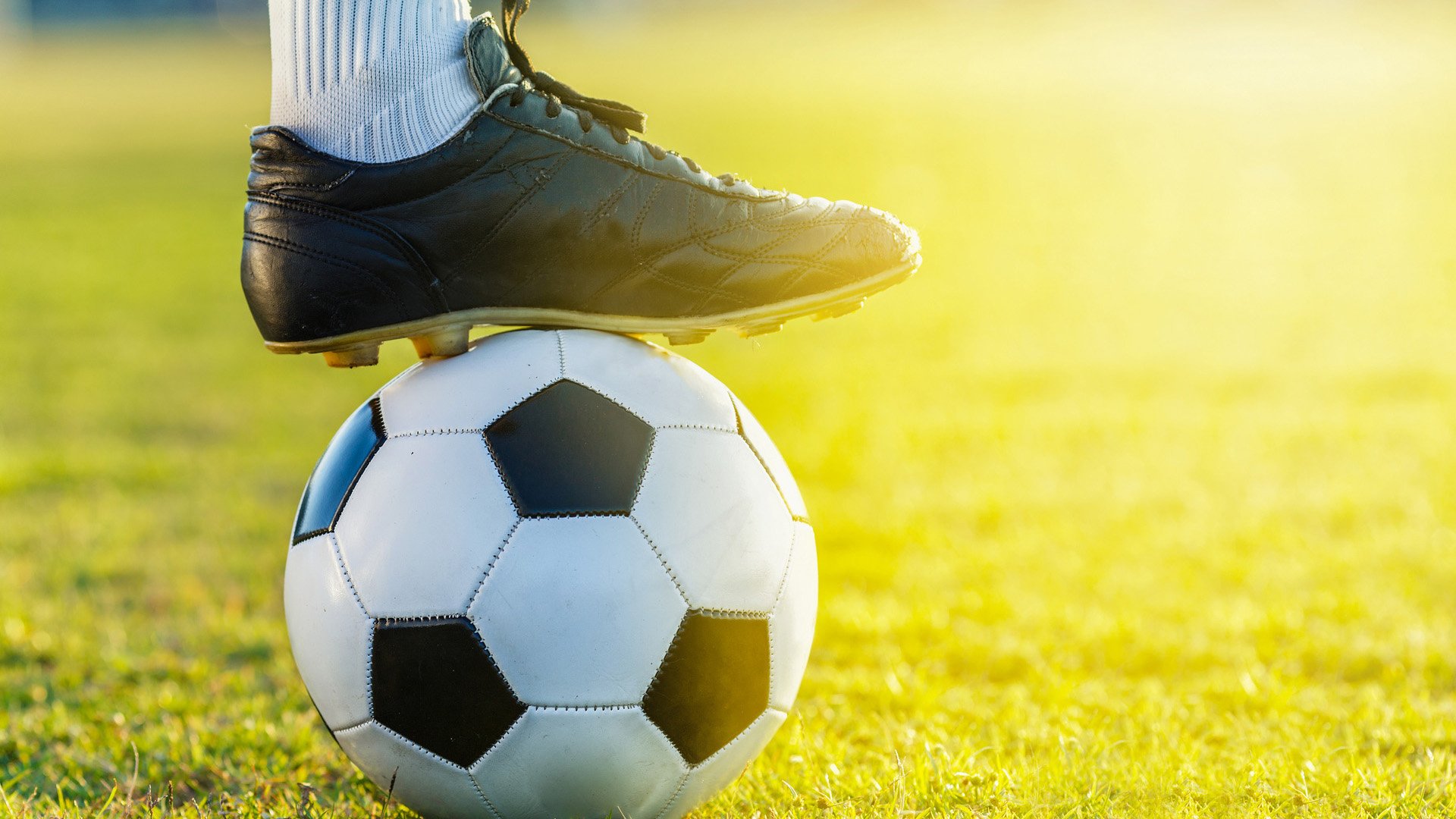 feet of soccer football player standing with the ball