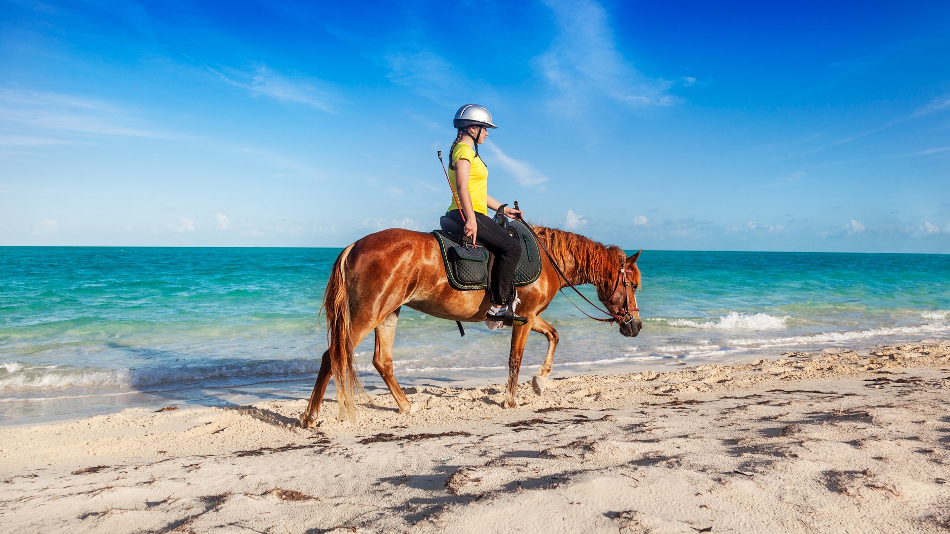 Teenage girl finishing a ride on Long Bay Beach, Providenciales, Turks and Caicos