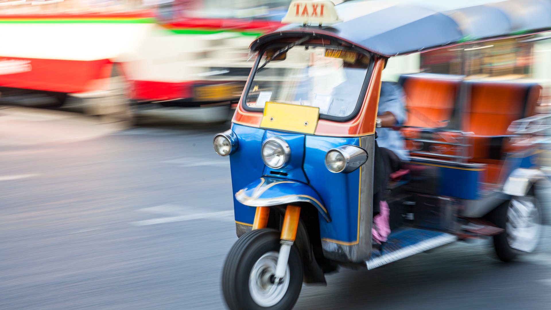 Man riding tuk-tuk on the street of Bangkok, Thailand.