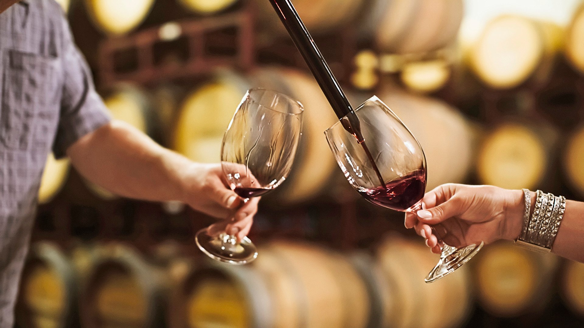 Caucasian couple tasting wine in cellar