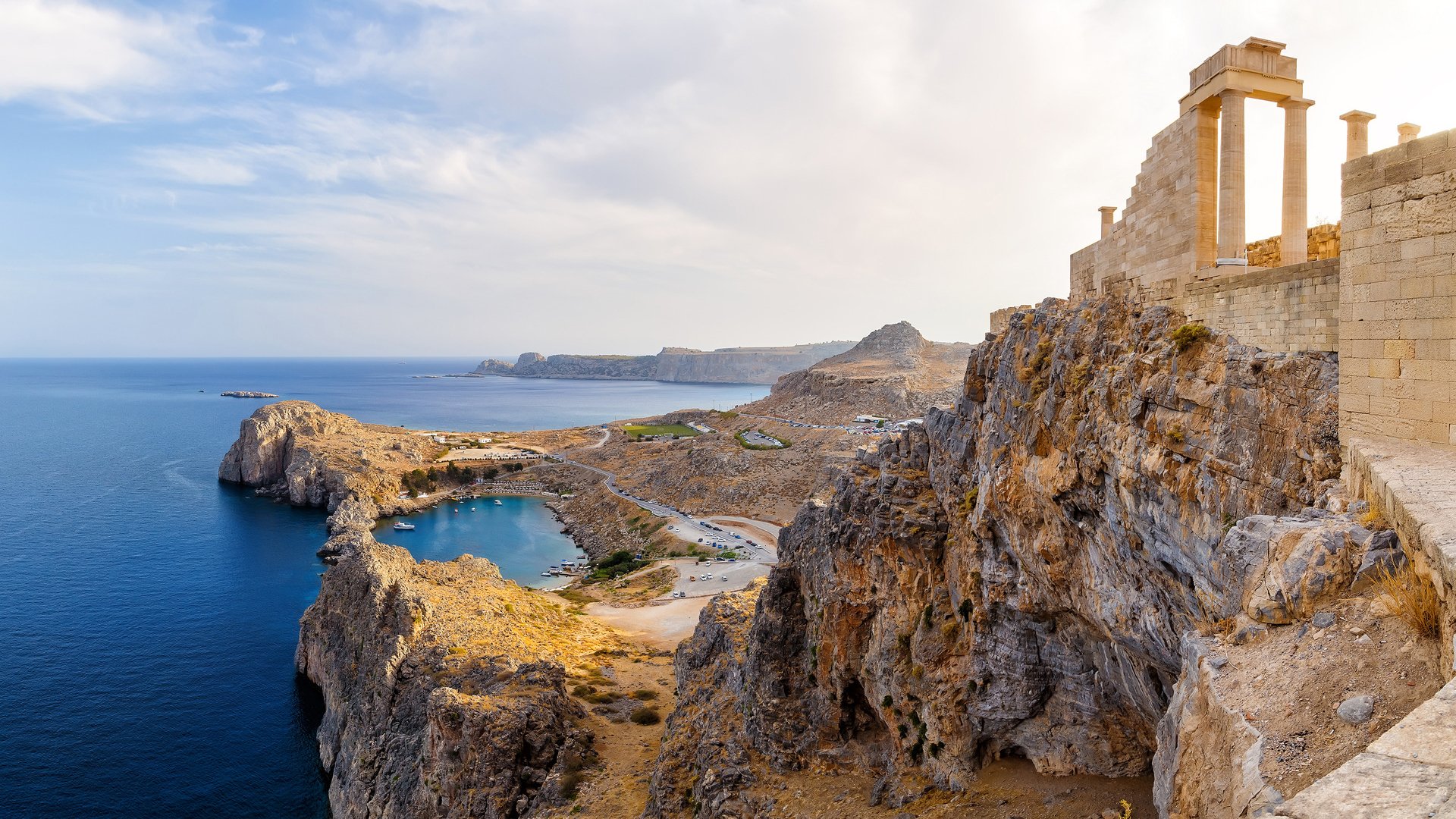 Greece. Rhodes. Acropolis of Lindos. Doric columns of the ancient Temple of Athena Lindia the IV century BC and the bay of St. Paul