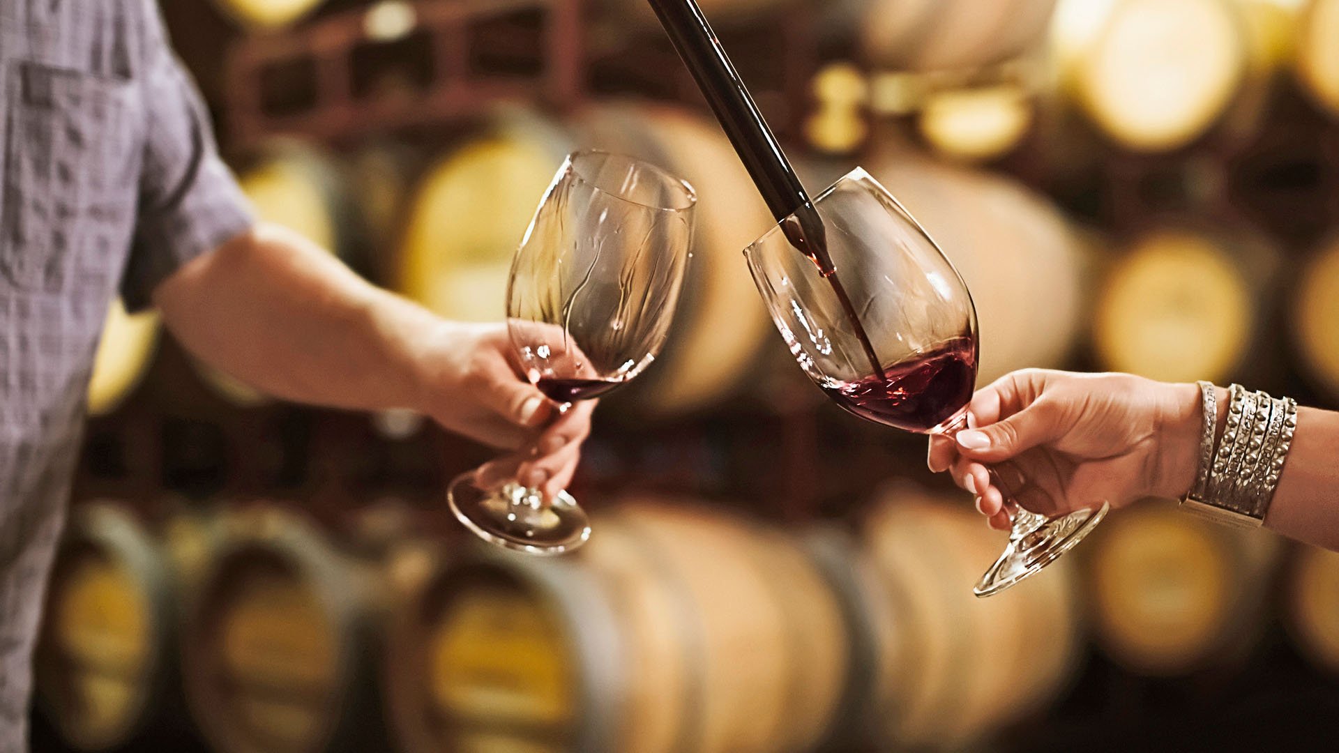 Caucasian couple tasting wine in cellar