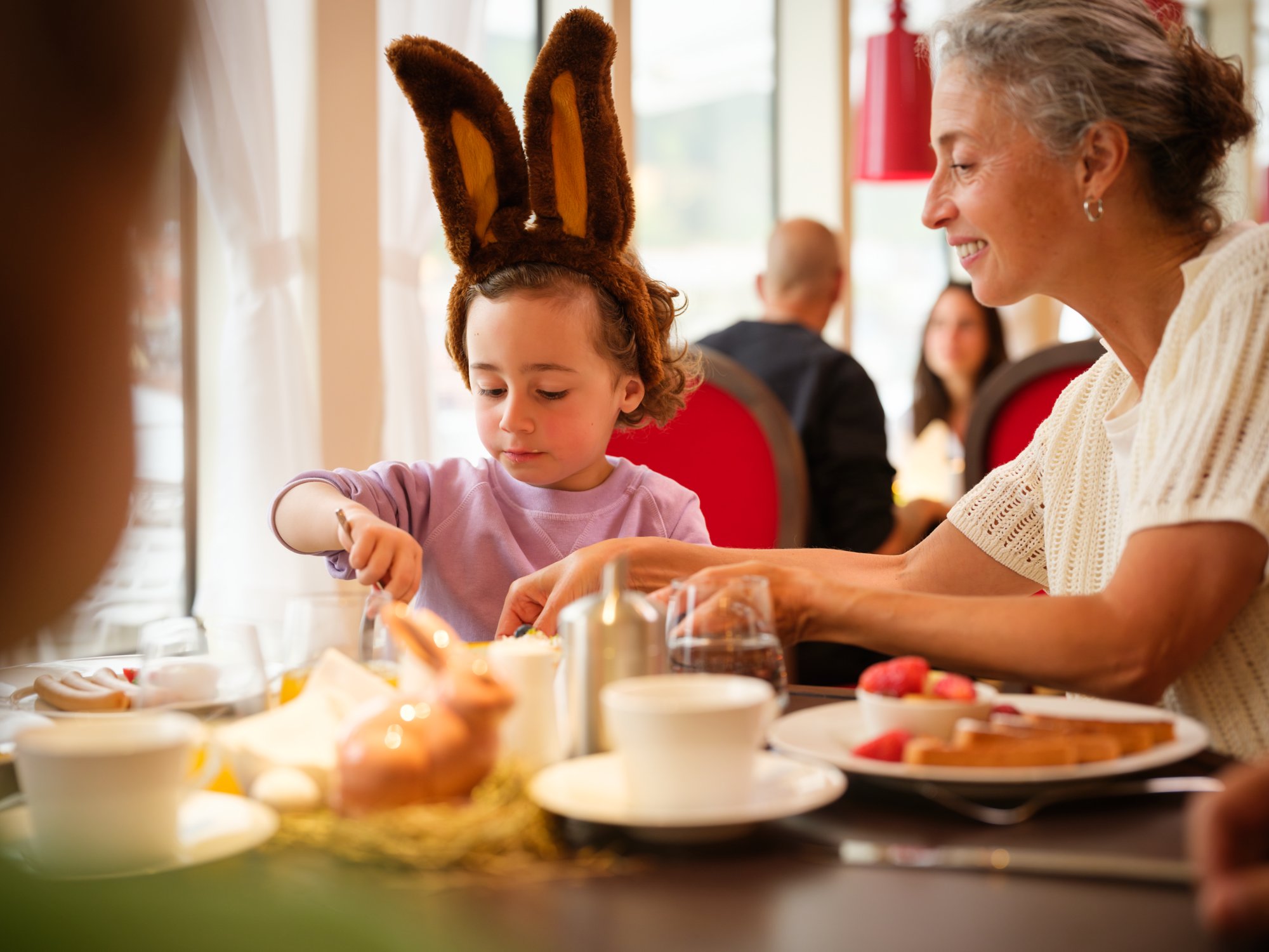 Ein Kind mit Osterhasenohren beim Essen