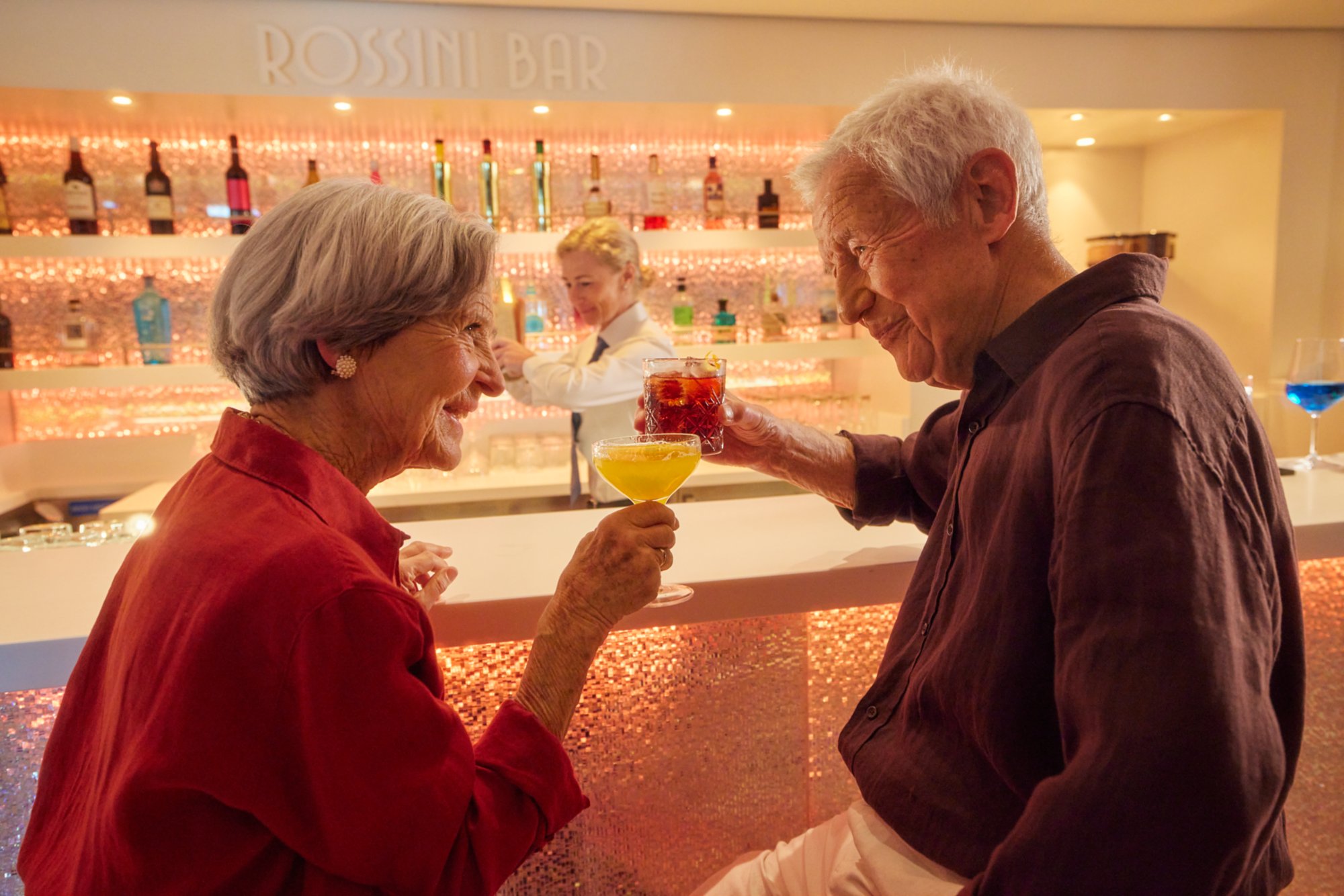 Älteres Pärchen stößt mit Cocktails in der Rossini Bar an.