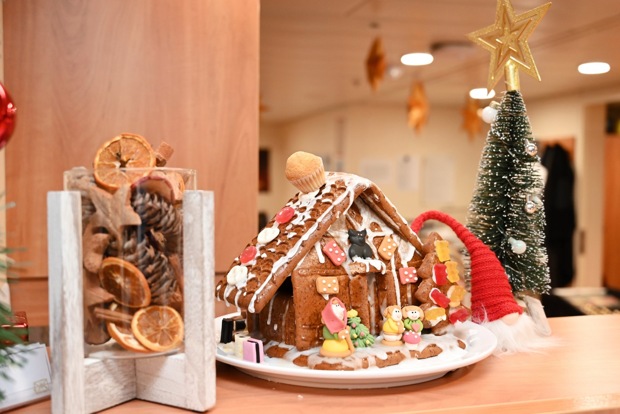 Lebkuchenhaus umringt von Weihnachtsdeko