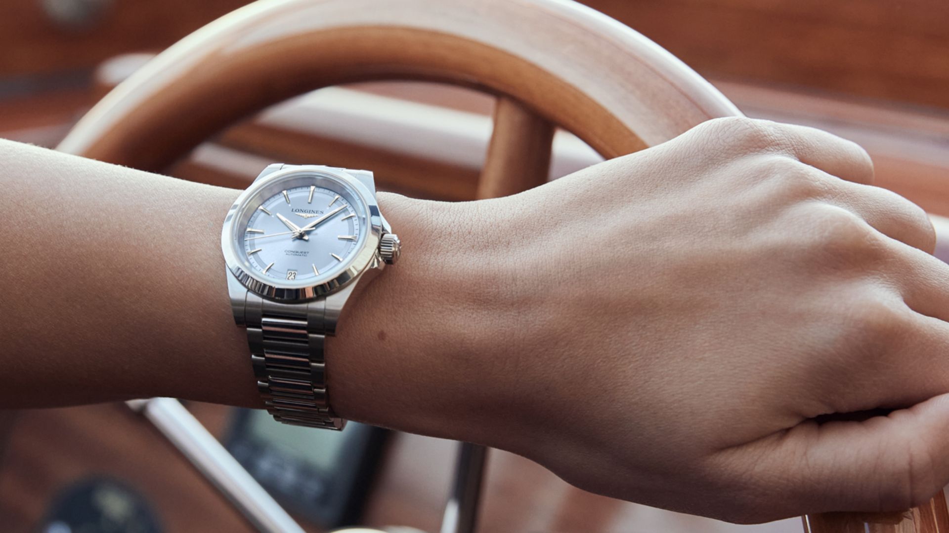 Frau ergreift das Ruder mit einer Longines-Uhr