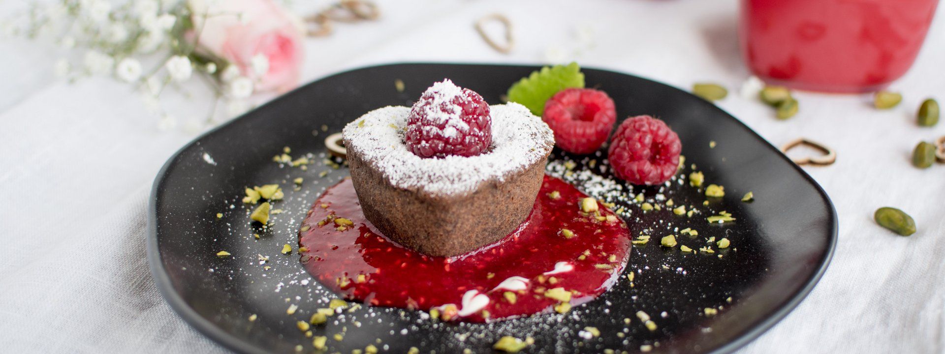 Schokokuchen angerichtet mit Himbeeren auf einem Teller