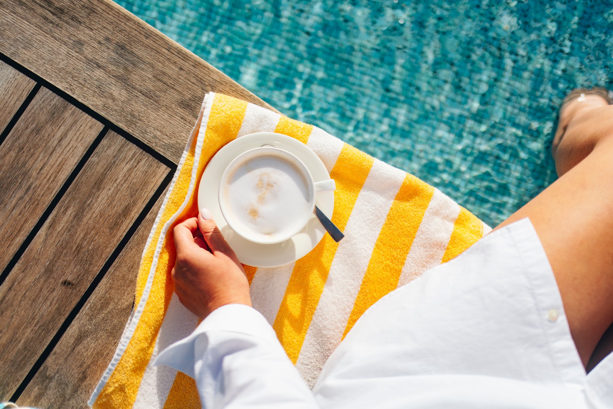 Frau mit Poolhandtuch und Kaffee