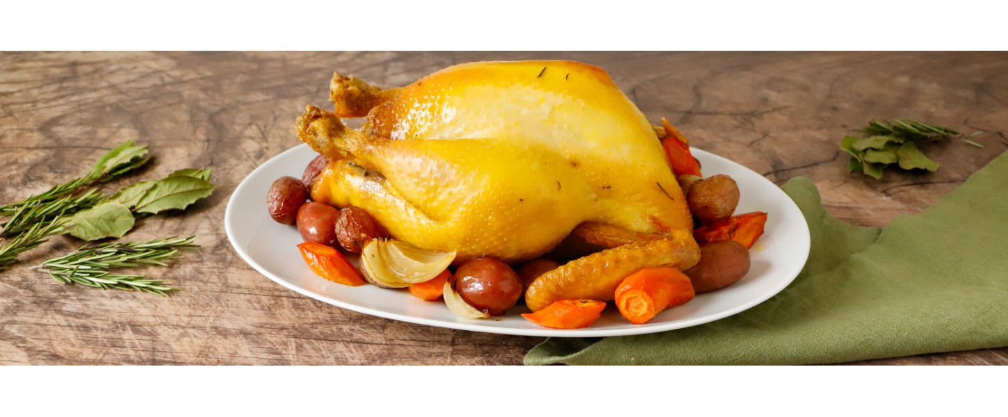 Un cappone ripieno dorato è servito su un vassoio con un contorno di verdure