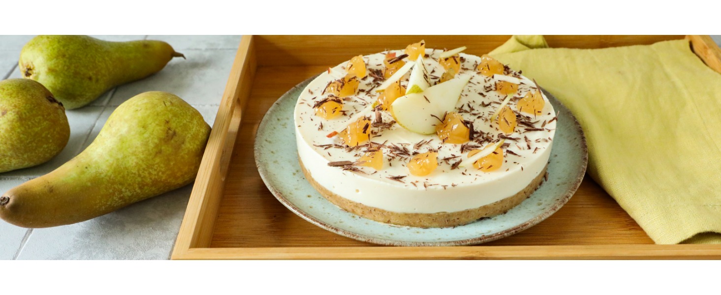 La cheesecake con confettura di pere e scaglie di cioccolato è servita su un vassoio in legno, decorata con fette di pera fresca 