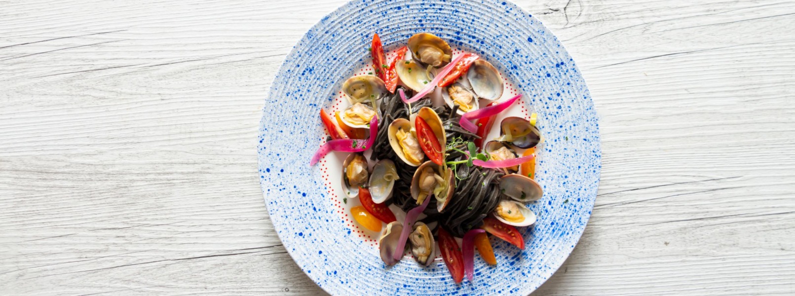 Linguine al nero di seppia con vongole e porro