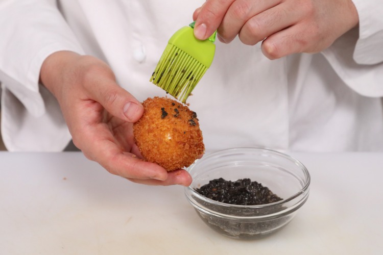 Spennellare di salsa tartufata l'uovo fritto