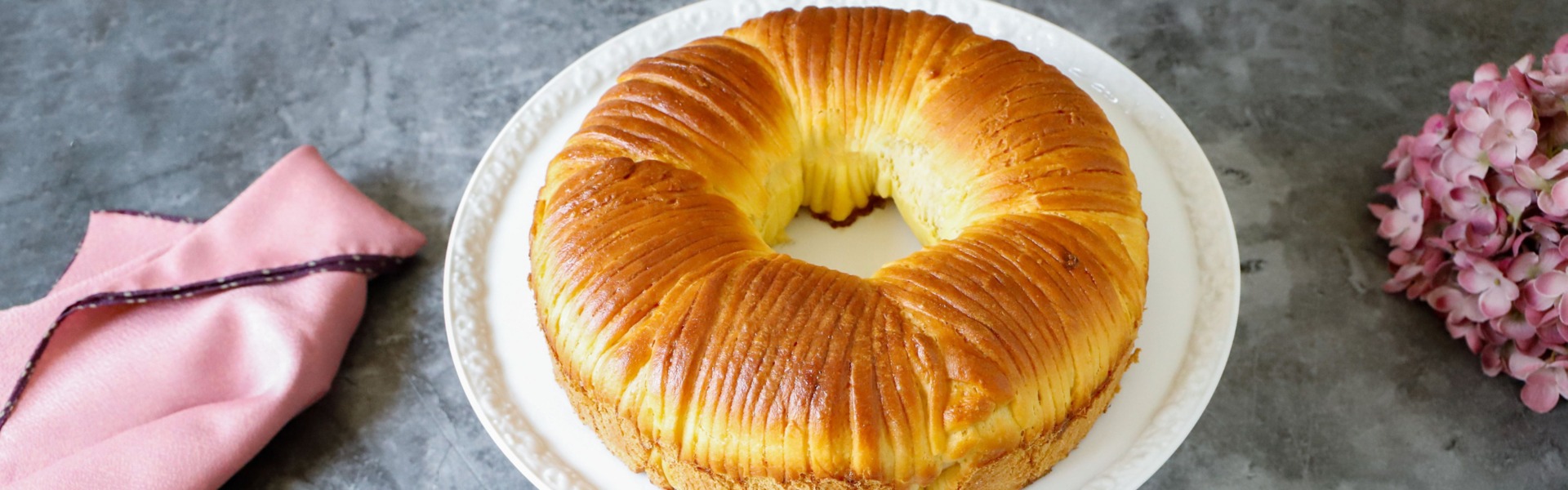 Un pan brioche che dalla forma ricorda un gomitolo di lana, su un’alzatina in porcellana