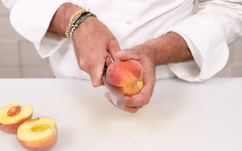 Tagliare le pesche per farcirle con crema di ricotta e miele