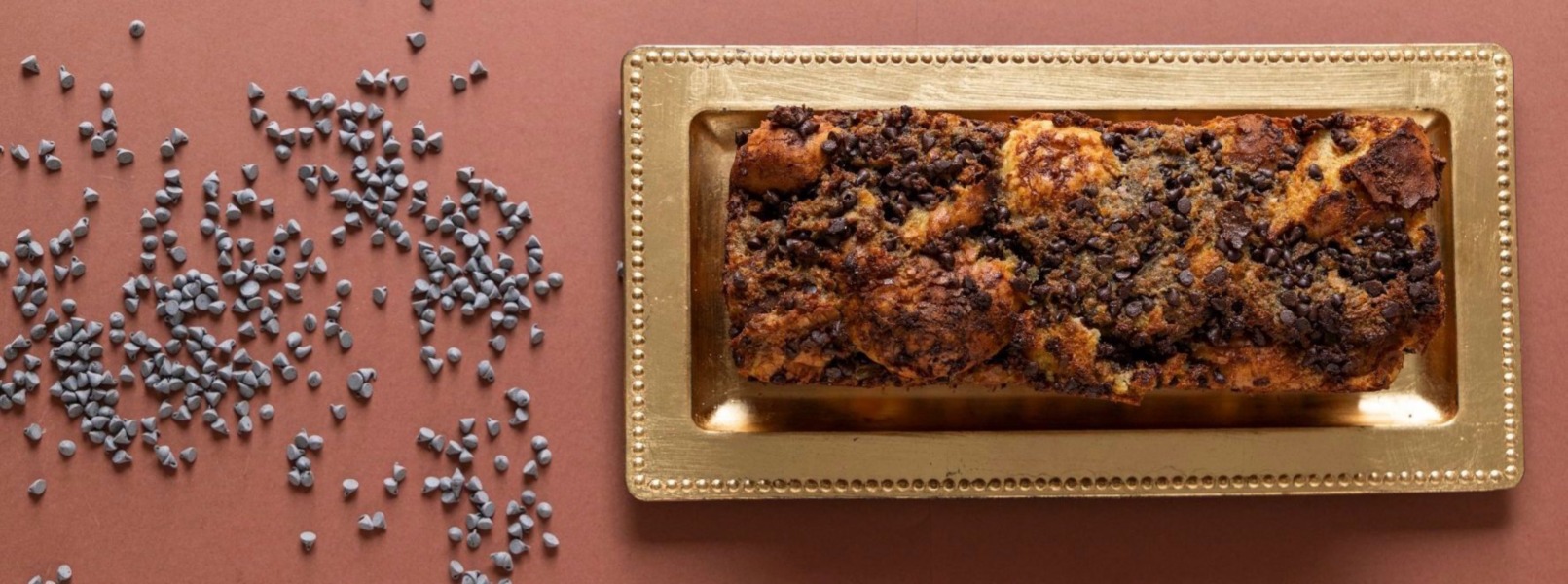 Un Pudding di pane raffermo e cioccolato disposto su un piatto dorato