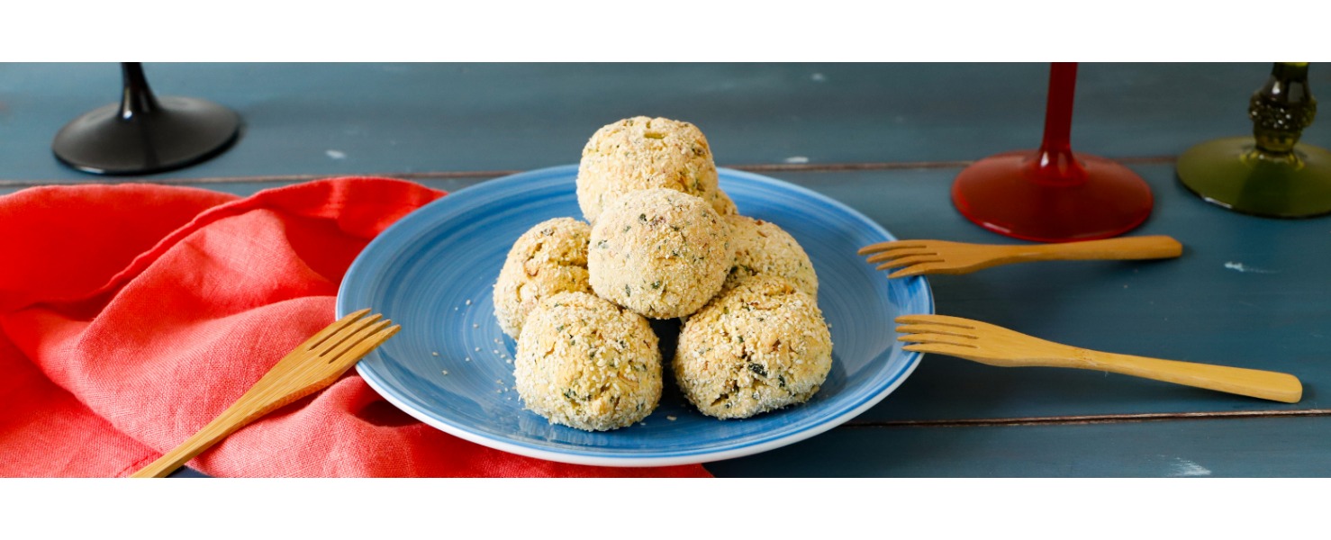 Polpettine di ceci servite su un semplice piatto colorato, pronte per essere divise durante un aperitivo